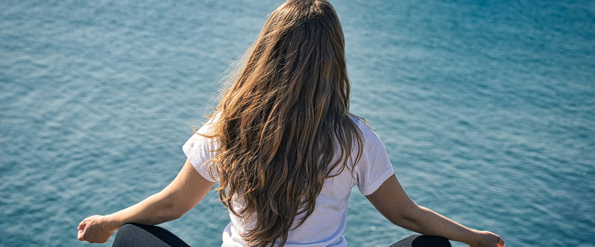 Person meditating by the water