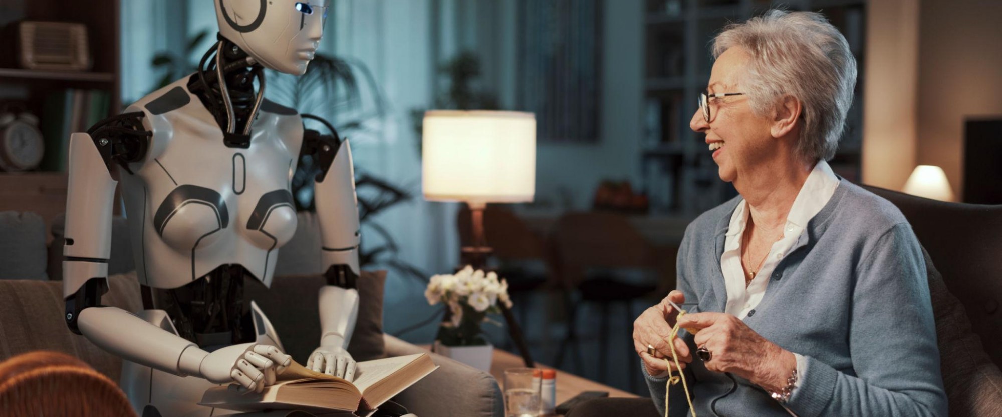 Companion robot reading beside an elderly woman knitting