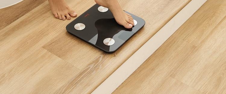 Bare feet stepping onto a smart body-composition scale