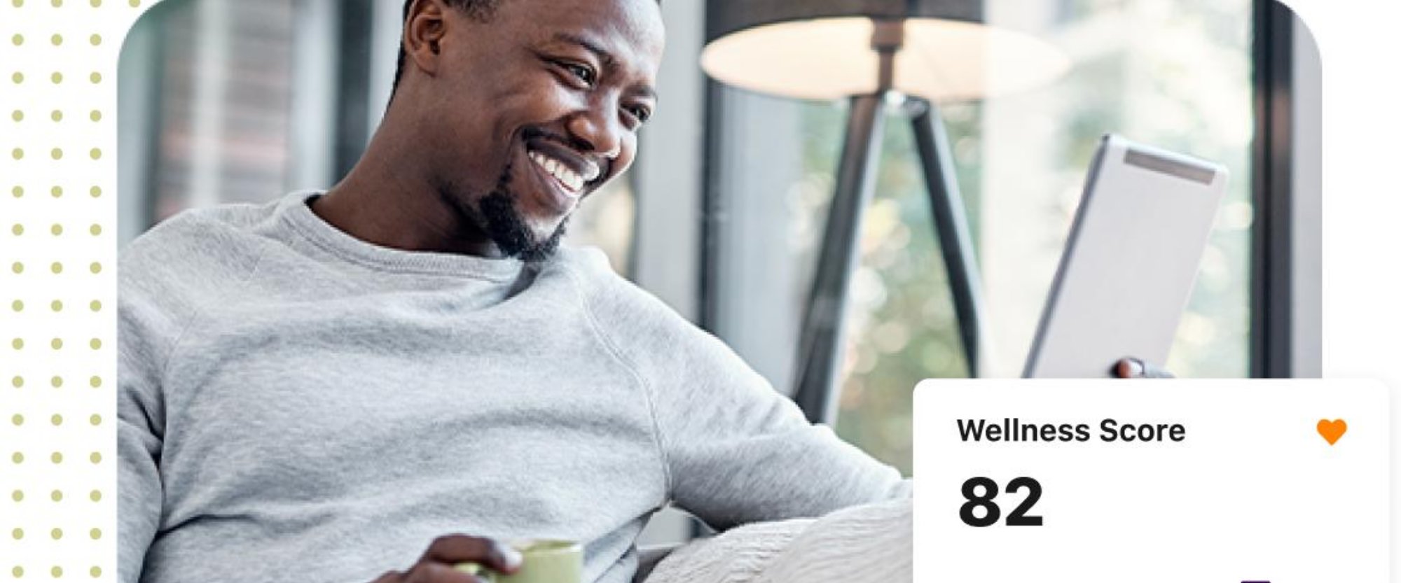 Smiling man relaxing with a warm drink and tablet